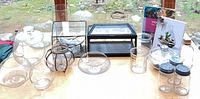 Wide view of all glass containers, terrarium cases and books on tabletop
