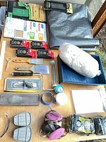 Overview of sanding supplies, tarp, paint tray, respirator, cartridges and accessories on table