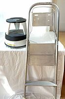 Folding aluminum ladder and rolling step stool side by side