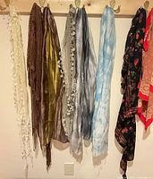 Eight scarves hanging on hooks, full view