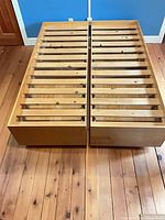 Two halves of queen platform frame with slats and drawer fronts
