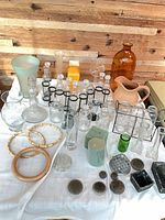 Overall lot of vases, bottles, frogs, hoops and foam displayed on table