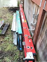 All three ladders stacked against fence