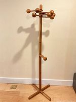 Full view of wooden coat tree showing height and base