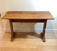 Front view of solid wood console table against wall