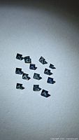 All twelve square cut blue sapphires on neutral background