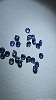 Group of small round blue sapphires on white background