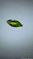Marquise-cut apple green peridot on neutral background