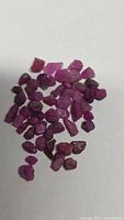 Pile of rough ruby crystals on white background