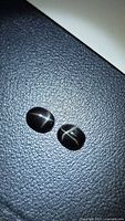 Pair of oval black star diopside cabochons showing star effect