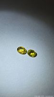 Two oval yellow sapphires on neutral background