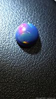 Top view of round black opal showing play-of-color