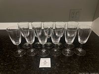 11 Dansk Ursula crystal wine glasses lined on countertop