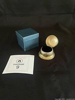 Ring box closed, lid open, and blue sleeve visible