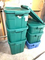 Stacked green and blue Rubbermaid totes with lids