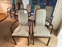 Front view of all eight matching dining chairs arranged in two rows