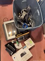 Overview showing tote of cables, HP Scanjet 4670, Audioengine D1 box, speakers, D-Link switch box, Apple adapter kit box