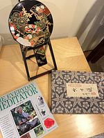 Mirror on stand, meditation book, fabric book box on tabletop