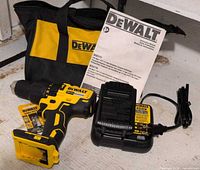 Drill, battery, charger, bag, manual visible together