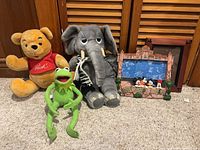 Group shot of three plush toys and Hollywood Tower Hotel frame
