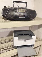 HP printer and Panasonic boombox on shelving