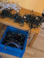 Strands on table and in blue crate: white-cord minis, green-cord minis, crate of multicolour C6 lights