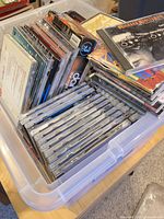 Plastic bin filled with numerous CD jewel cases