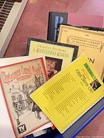 Top view of tote showing several music books: Christmas Carol Book, A Christmas Carol, Schirmer volume, spiral-bound 100-song book