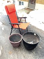 Folding chair, black planter, brown planter