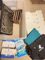 Lot overview showing masks boxes, gloves pack, wall organizer pieces, wicker organizer, binder, laptop bags and clear bin