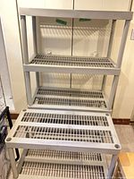 Front view showing stacked grey plastic shelving sections