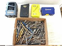 Overview of four drill bit cases and box of loose bits