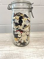 Front view of glass jar showing buttons inside