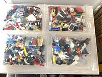 Four clear bags filled with assorted LEGO elements displayed on table