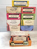 Stack of 10 small boxed puzzles plus two narrow boxes and one larger Guild box