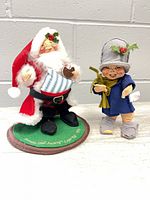 Front view of both Annalee dolls: Santa on base and child caroler