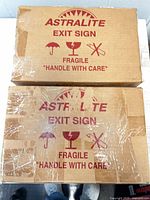 Two stacked Astralite exit sign cartons