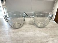 Two identical clear glass mixing bowls side by side