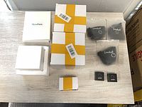 Sealed packaging with Lensball pouches, white boxes, and smaller accessory boxes arranged on table