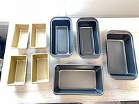 Eight loaf pans arranged by size and color
