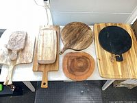 Six of the eight cutting boards displayed on table