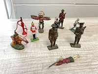 Group view showing all eleven metal miniatures on tabletop