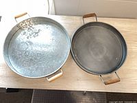 Both round trays side by side showing sizes and handles