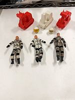 Group shot of 3 figures, 3 vehicles, 2 helmets