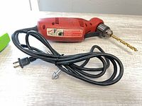 Full view of Milwaukee drill with cord and drill bit