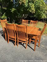 Dining table with six slat-back chairs, angled view
