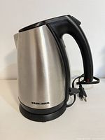 Full view of stainless steel Black & Decker electric kettle on base with cord