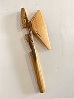 Full view of carved wooden ceremonial axe, front