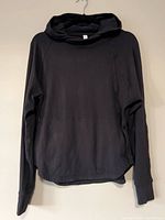 Full view of black Lululemon pullover hoodie on hanger