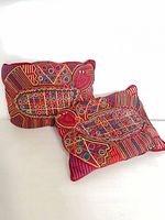 Two red mola pillows with turtle designs front view